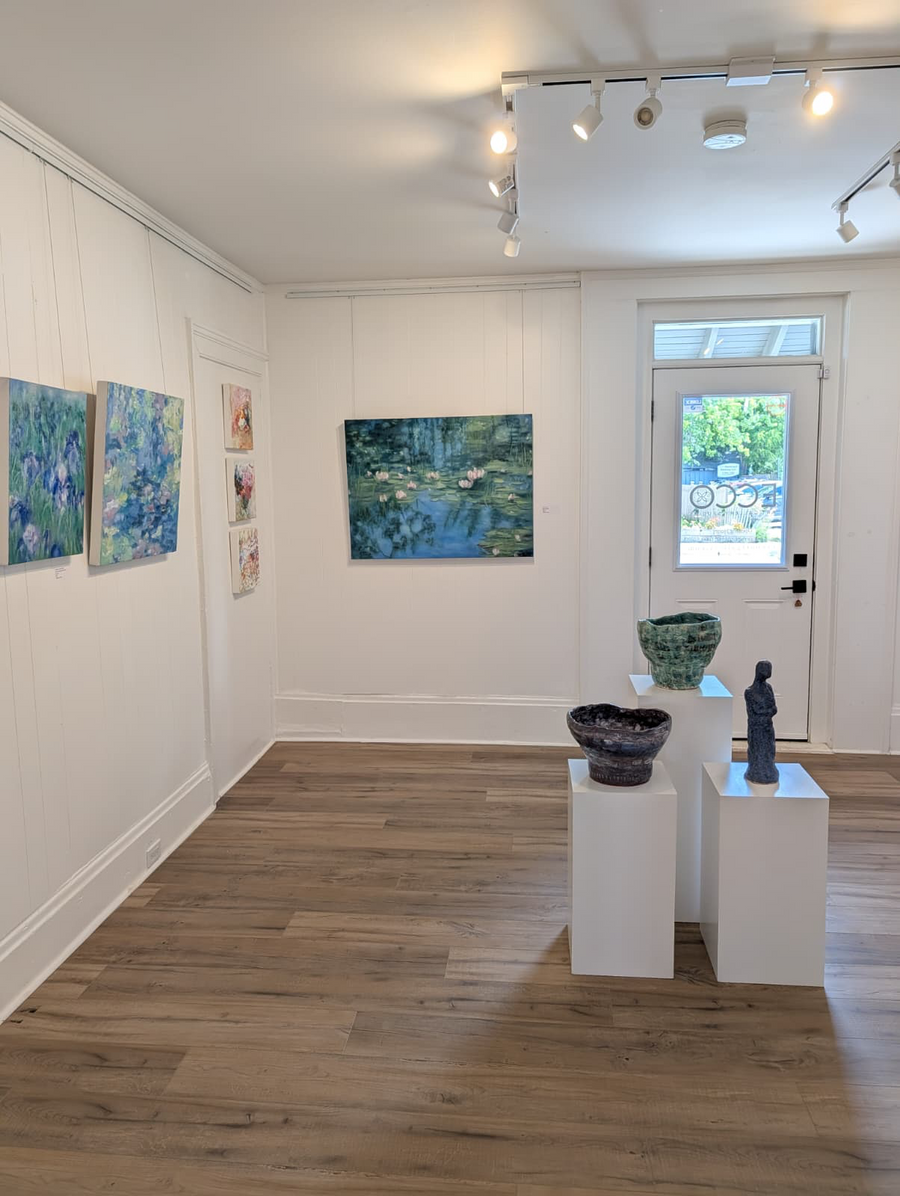 ECCO gallery installation with blue and green paintings and ceramic sculpture
